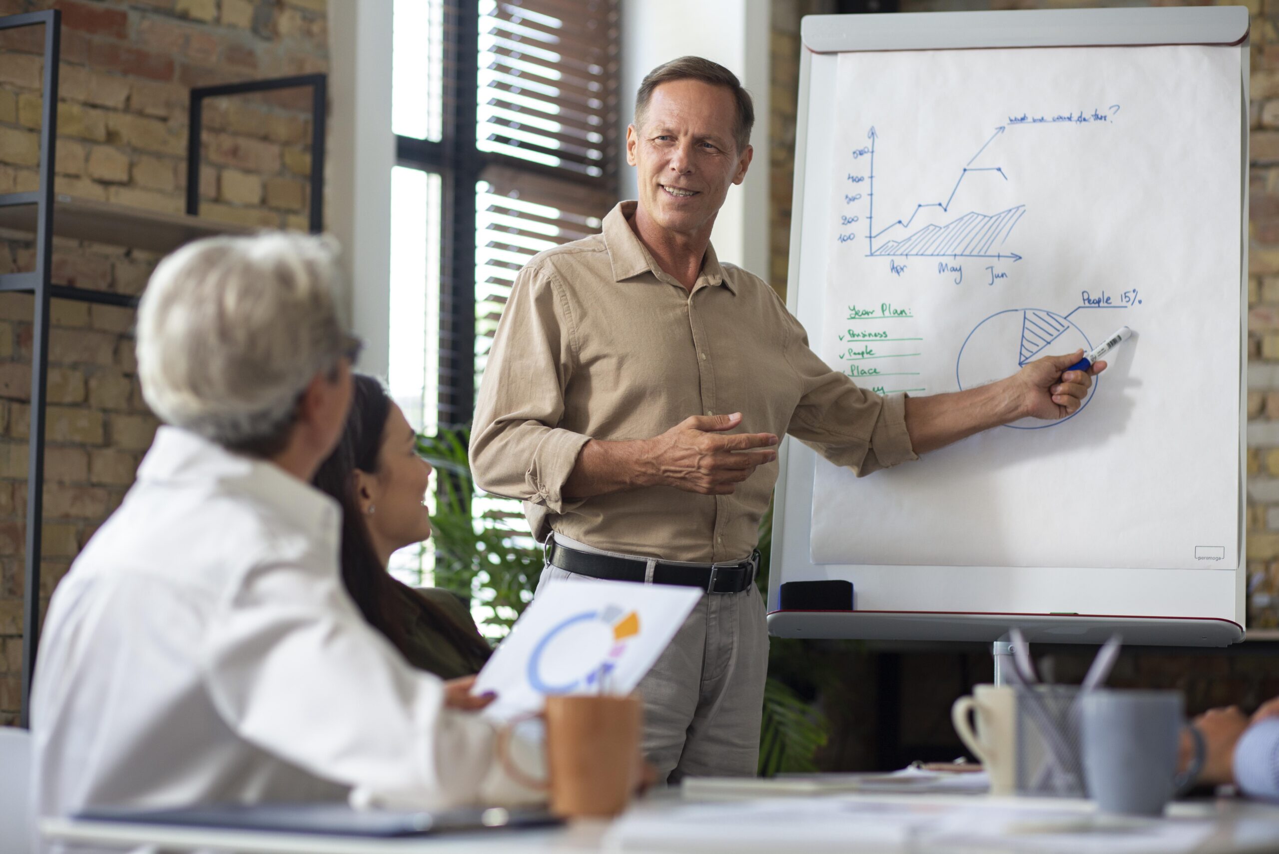 Person presenting information on whiteboard in meeting